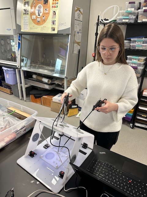 Bella trying the laparoscopic surgery trainer.
