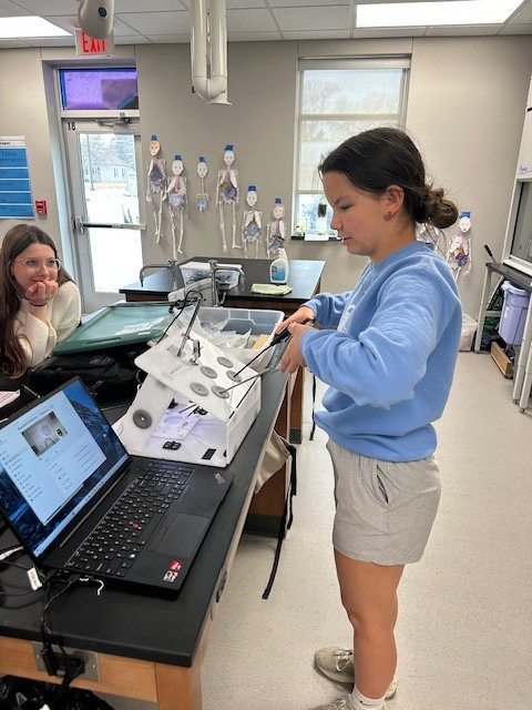Cheyenne trying the laparoscopic surgery trainer.
