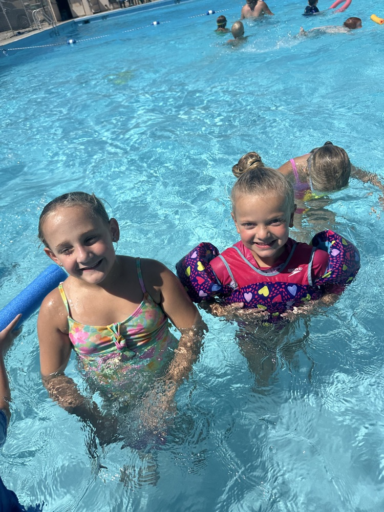 Two students smiling in a pool