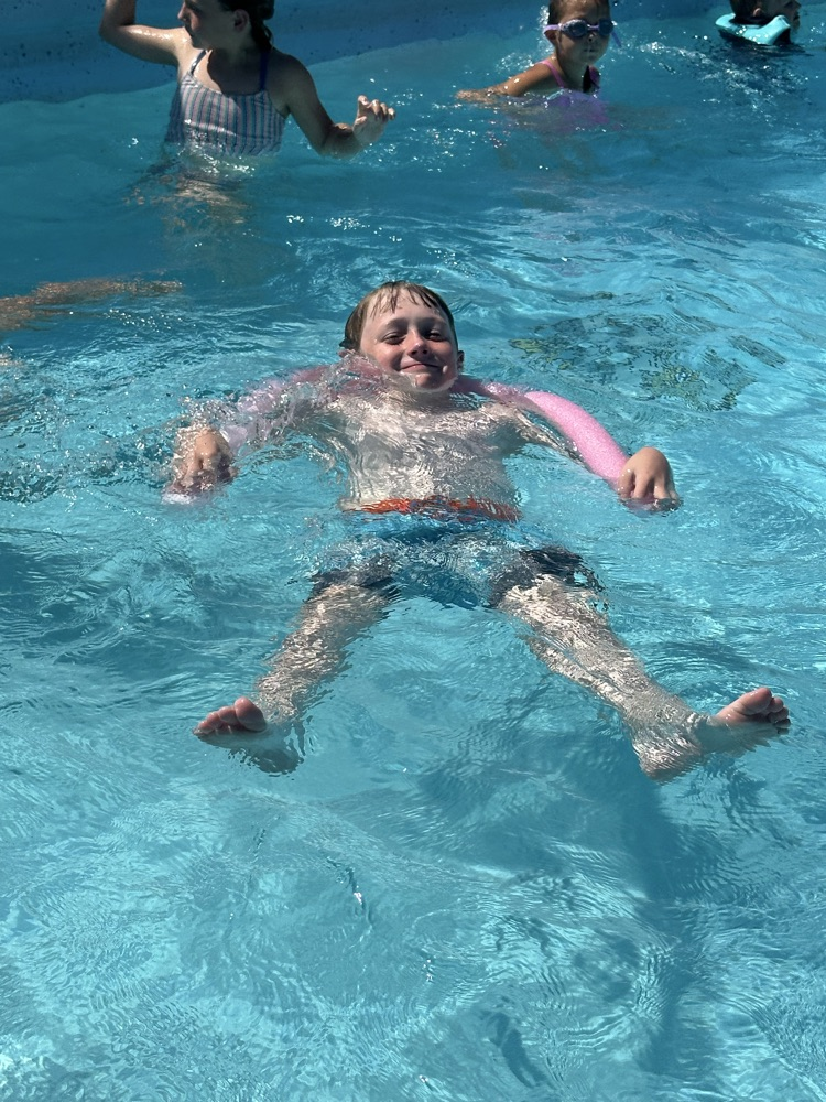 One student floating in a pool