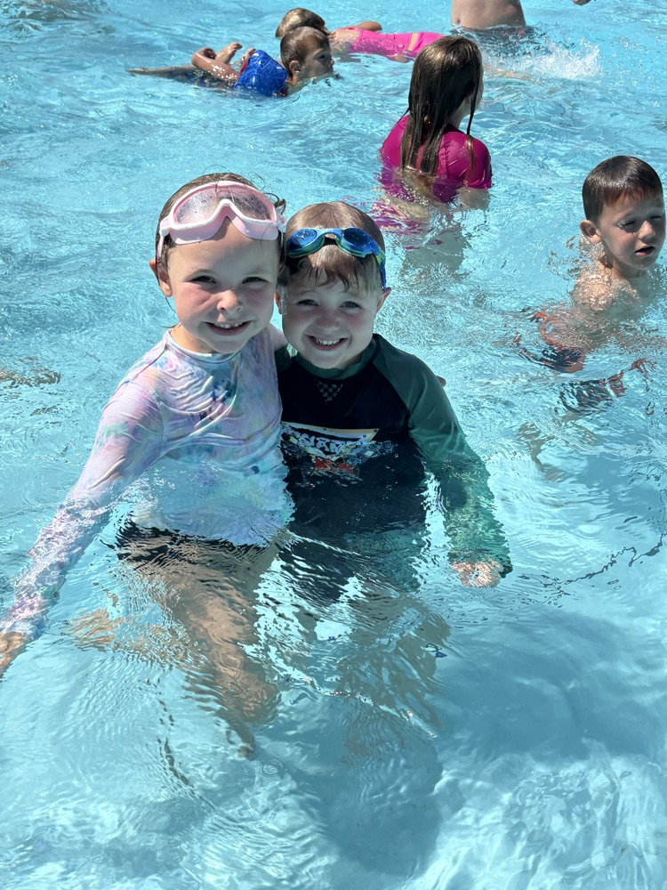 Two students smiling in a pool