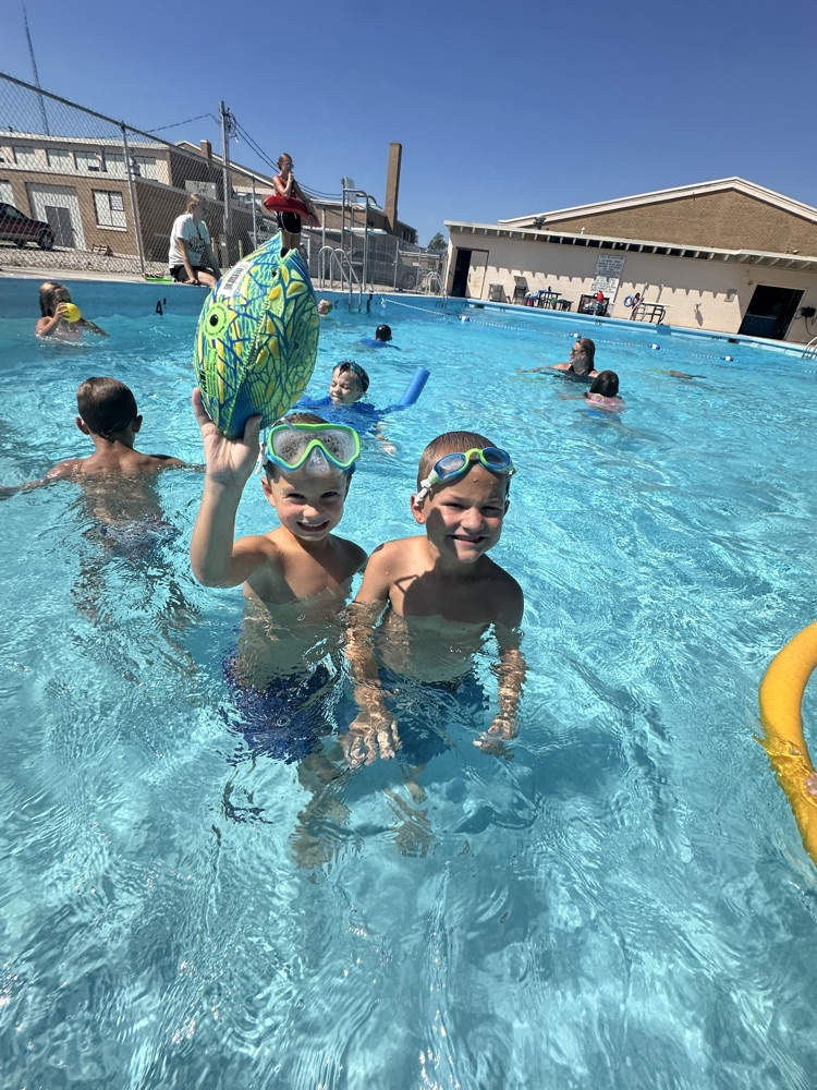Two student students smiling in a pool