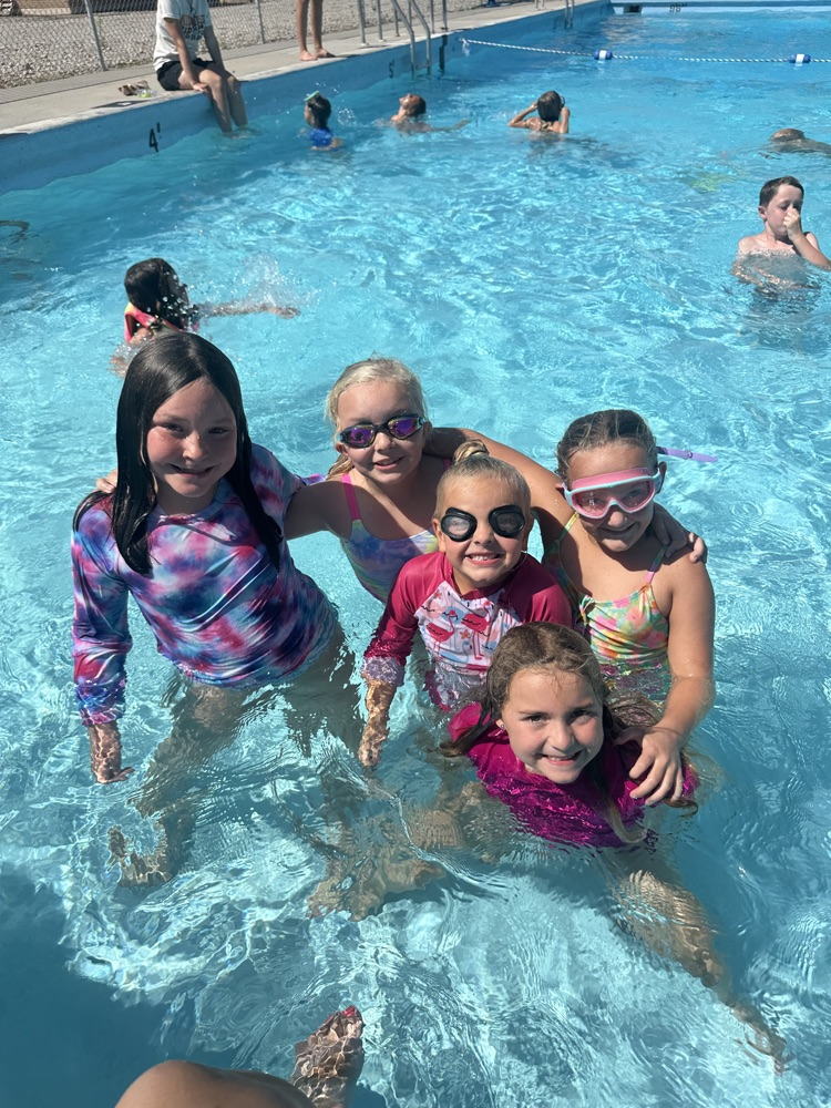 Five student smiling in a pool