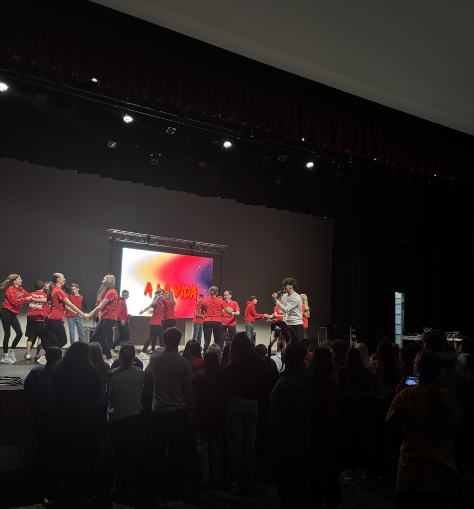 Students dancing behind Emanuel while he sings
