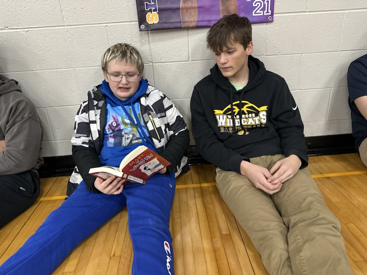 Elementary student reading to high school student