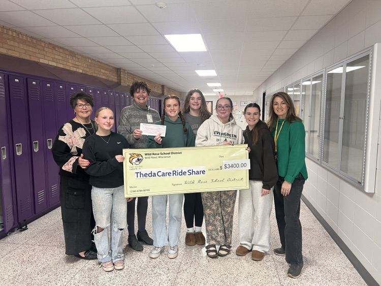 girls basketball team holds check for $3400 from Box Out Cancer