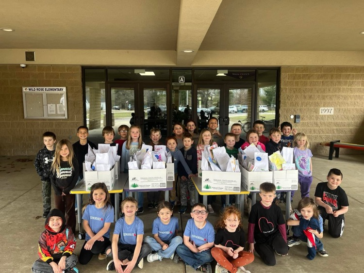 first graders pack bags for Meals on Wheels