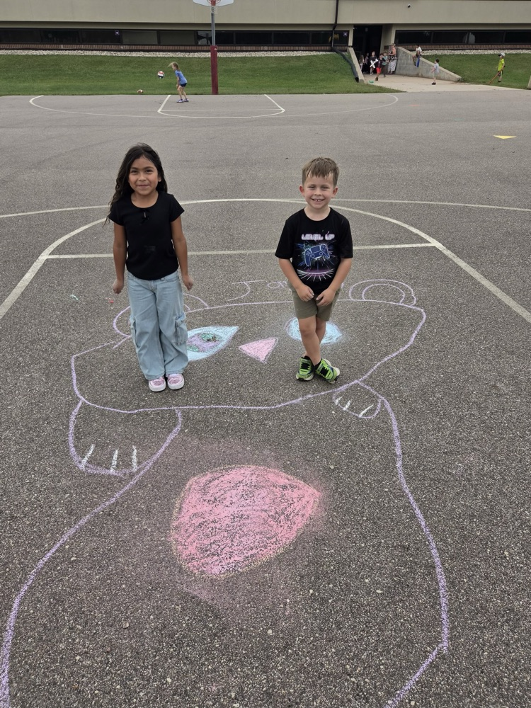 two WRE students stand by chalk art