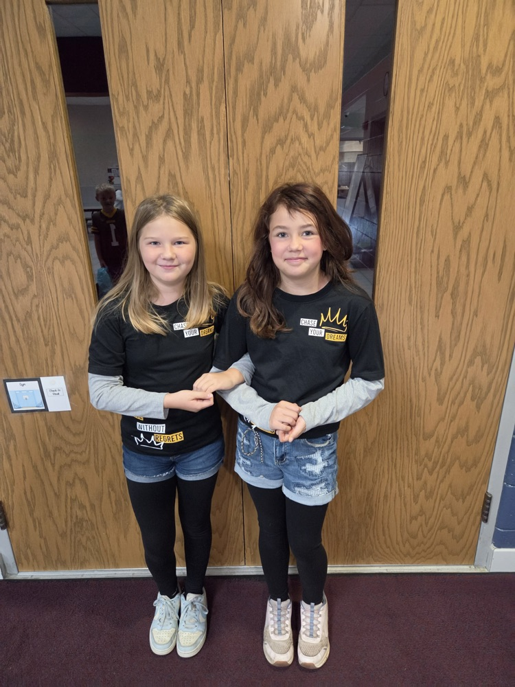 two girls stand next to each other in matching outfits 
