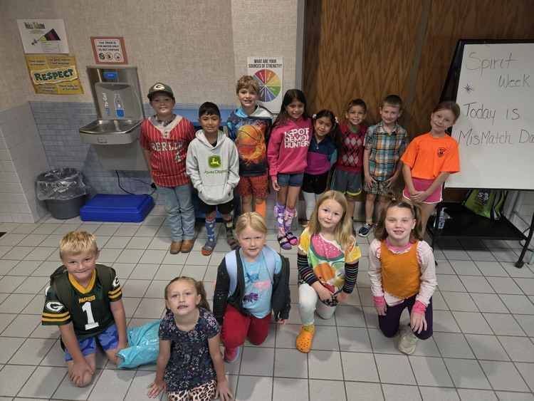 group of 13 WRE students smiling in mismatched outfits