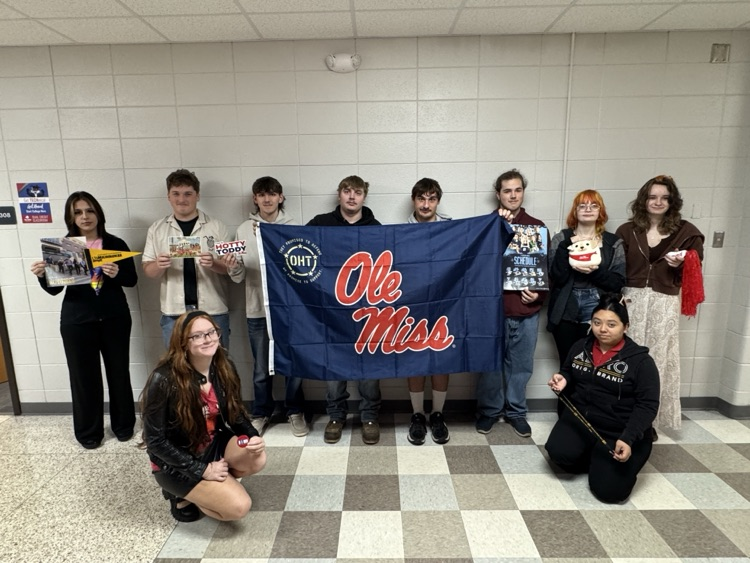 students pose with college school spirit items