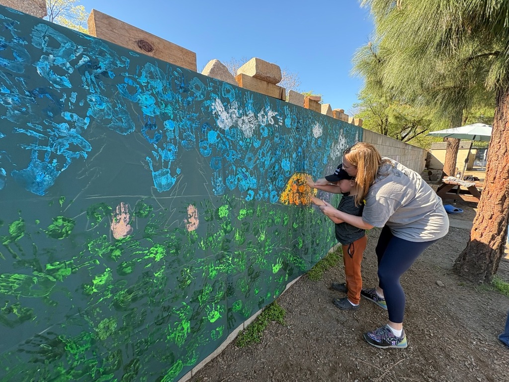 Melissa helping a student contribute to our new all school mural!
