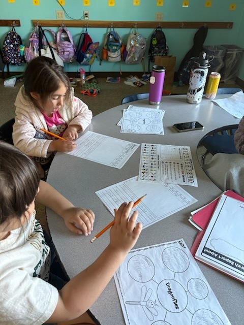 A group of students from our Dandelion class working on writing independently.