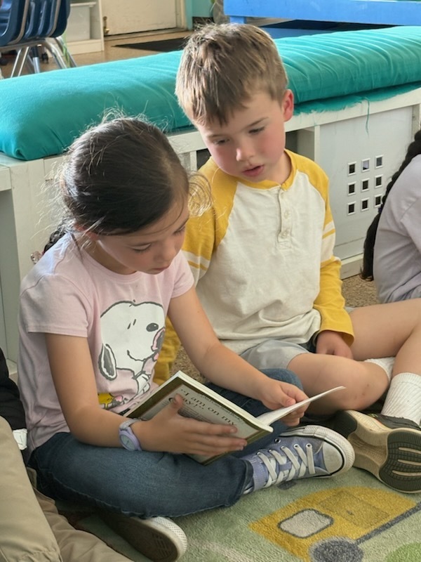 Another due of a fist grader reading to a kindergartner.