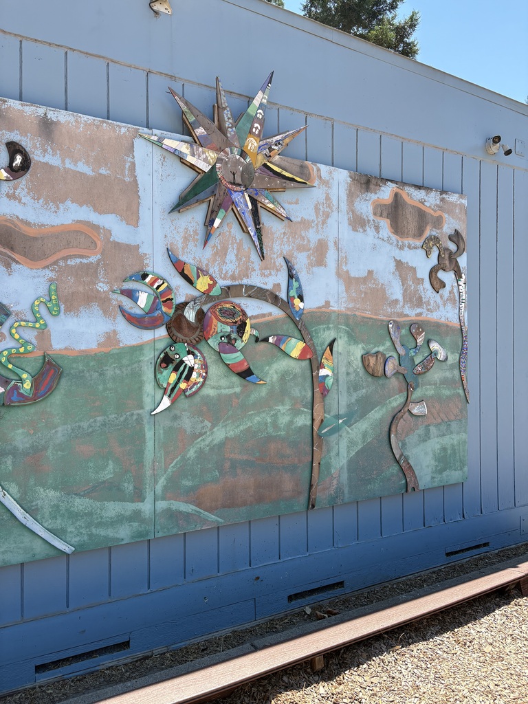 Here is a photo of our all-school mural made of painted wood pieces. Together, the different pieces make up a sun and flowers.