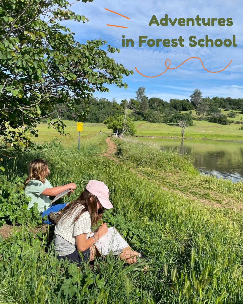 A photo of two students sitting in a green field with a lake and blue sky in the background. They are working on a writing assignment in their notebooks. In the top right corner, there is text that says; "Adventures in Forest School" with orange emphasis lines around it.