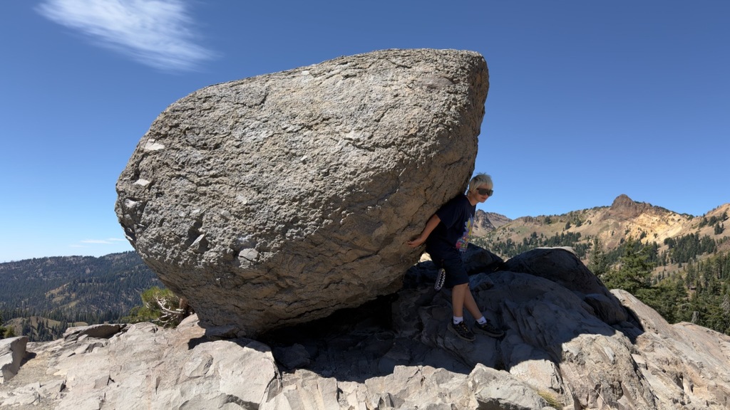 Here is a student on top of a summit "holding" up a boulder on his back. He is posed in a way that looks like he is keeping the boulder from falling.