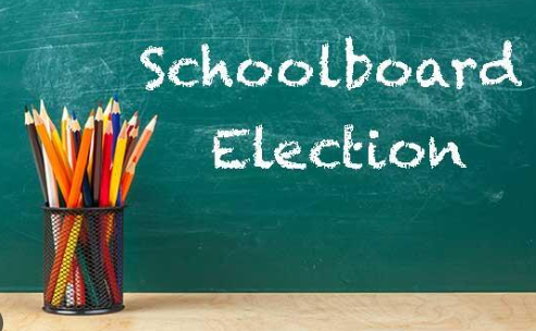 School Board Election on a chalkboard with a jar full of pencils in the front of it on a table.