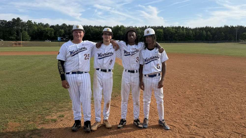Group photo of four Wilkinson County High School baseball seniors standing on the field during Senior Night. The students—Devin Mercer, Thomas Mobley, Jaden Ford, and Zechariah Coats—are pictured together in baseball attire, smiling and posing as they are recognized for their contributions to the team.