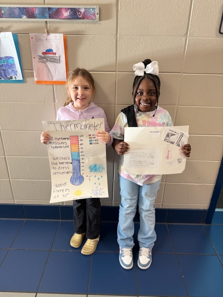students holding their project posters