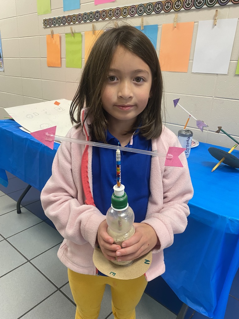 student holding wind vane
