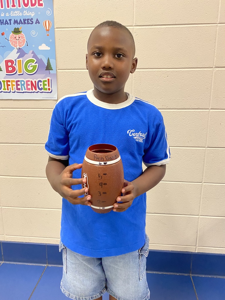 student holding a rain gauge made out of a football