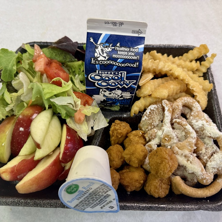 A school lunch tray featuring popcorn chicken, powdered sugar-covered funnel cake waffles, crinkle-cut fries, fresh apple slices, mixed greens with tomatoes, ranch dressing, and milk