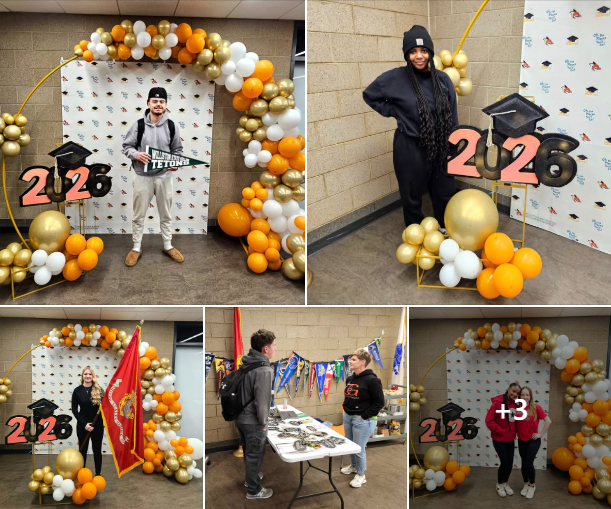 students with balloon decorations and 2026 graduation sign holding flags