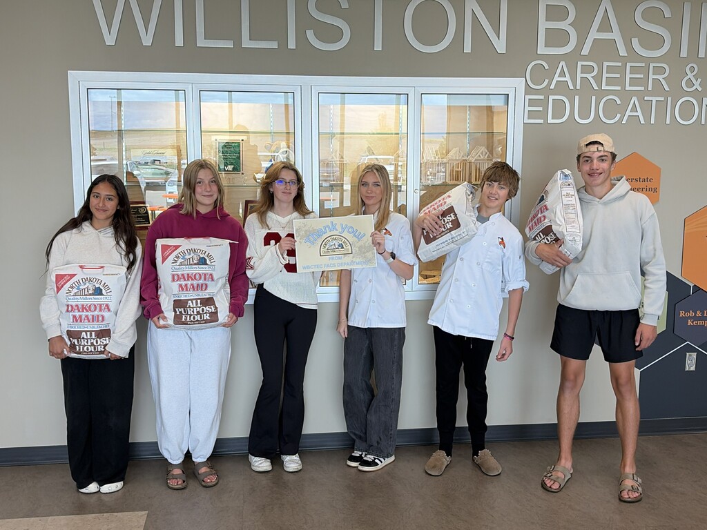 6 WHS students holding bags of flour and a sign to thank a donation from ND Flour