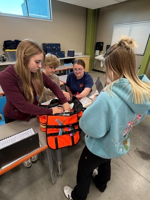 4 students checking EMT bag for inventory