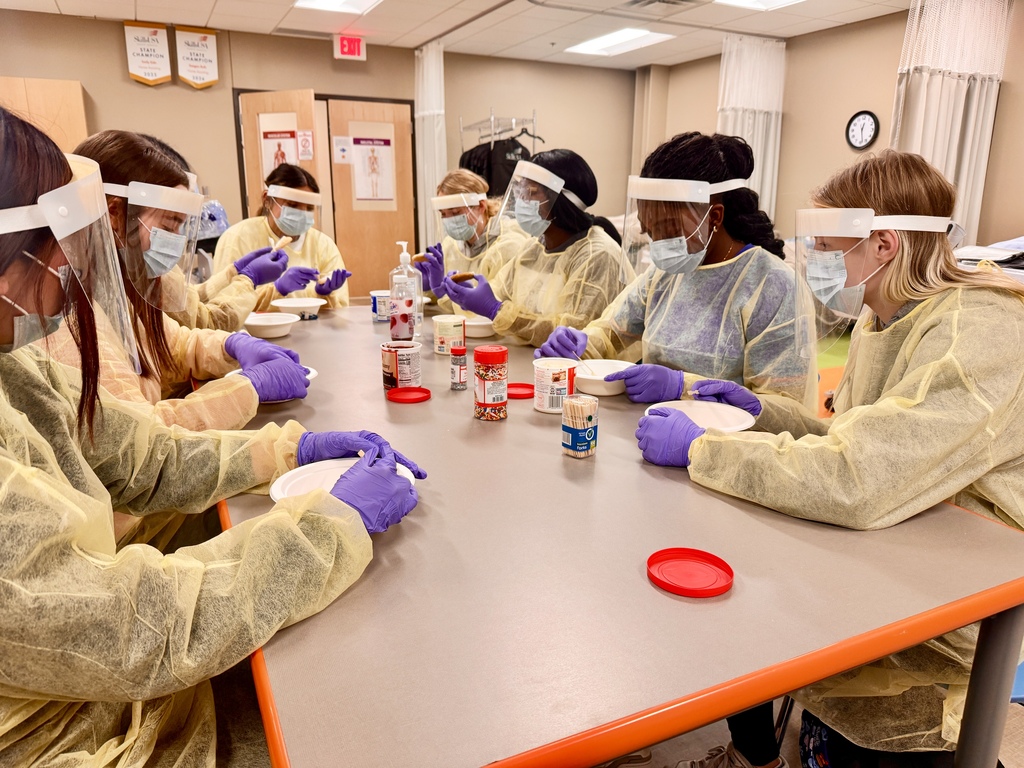 7 students in PPE gear decorating cookies