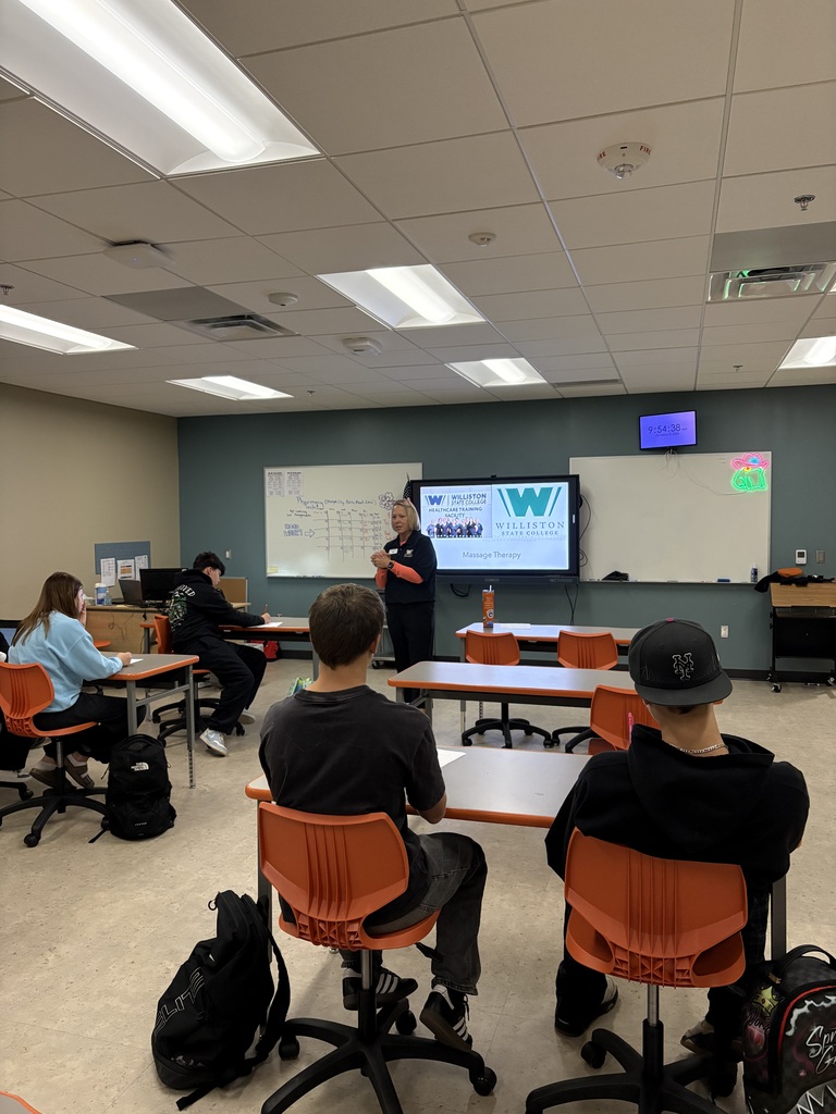 4 students in classroom listening to guest lecturer