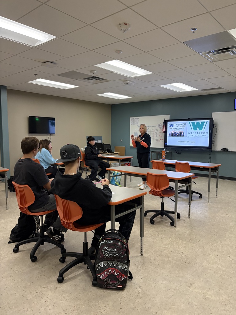 4 students in classroom listening to guest lecturer