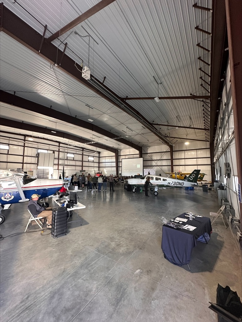 group of students and vendors set up in Bismarck Airport hanger