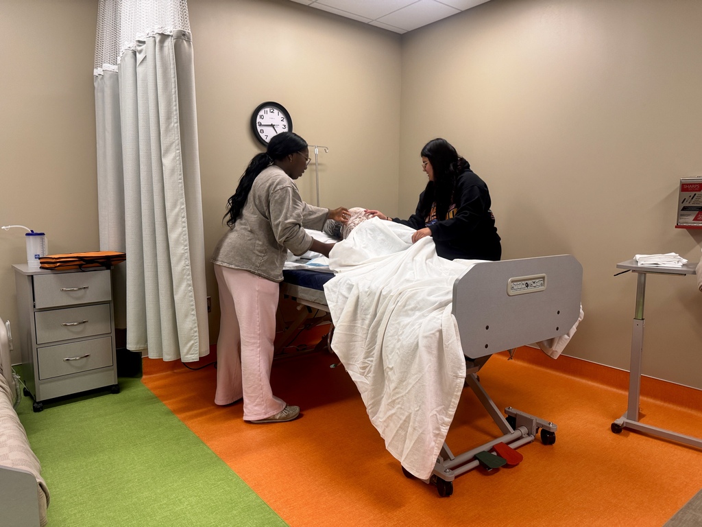 2 nursing students making a hospital bed