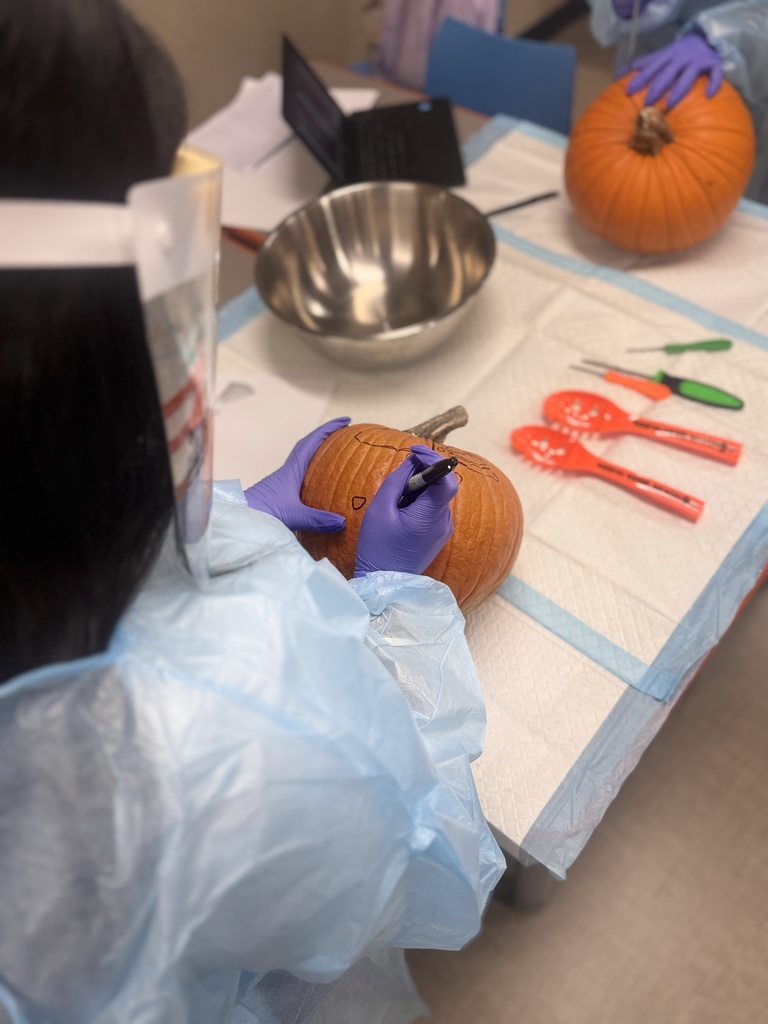 close up of student carving pumpkin