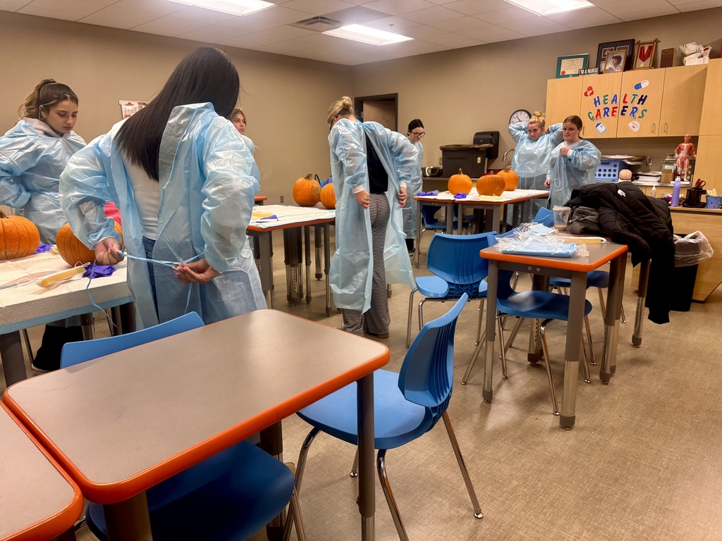 7 students suiting up for pumpkin carving