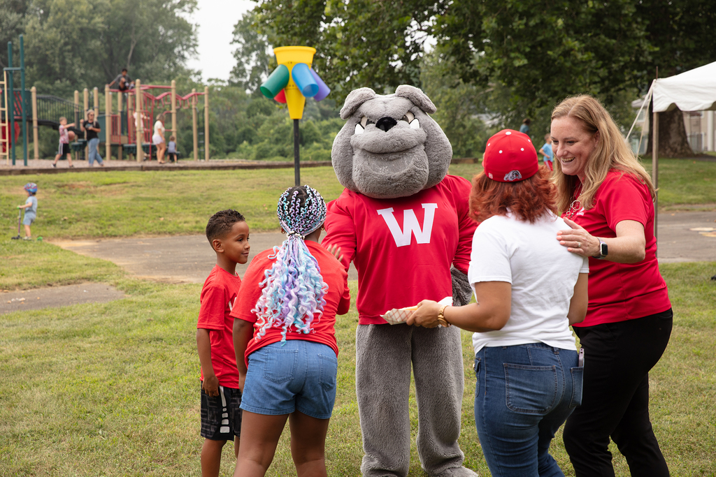 Bulldog mascot shaking hand with child
