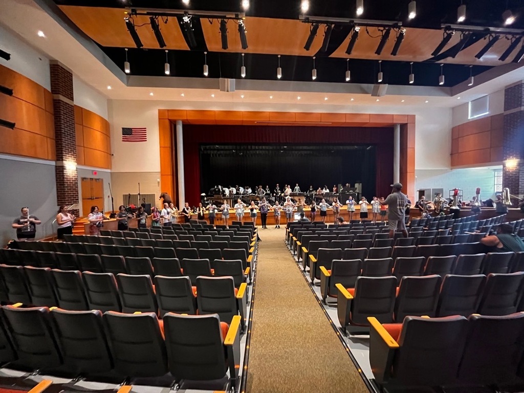 students in auditorium practicing with instruments