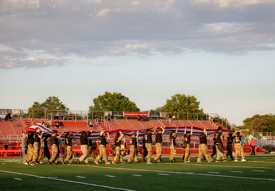JROTC walking onto field holding flag