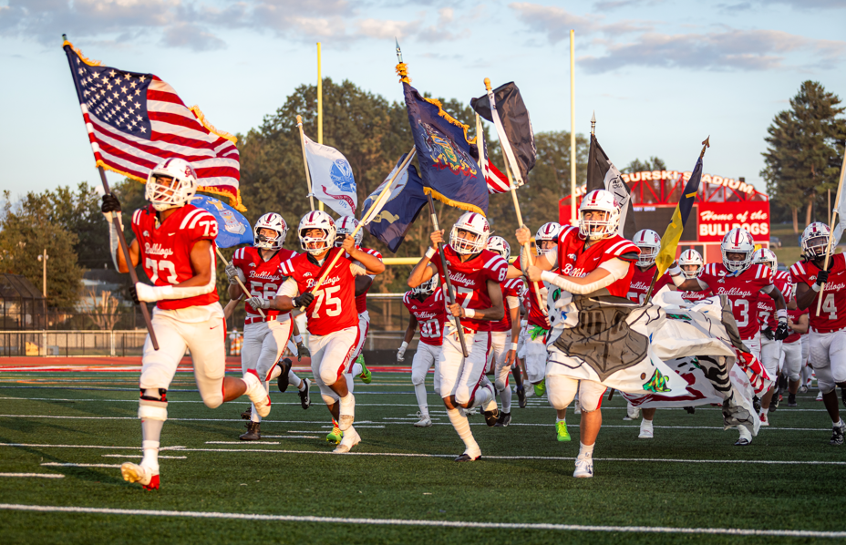 Players running onto the field with flags