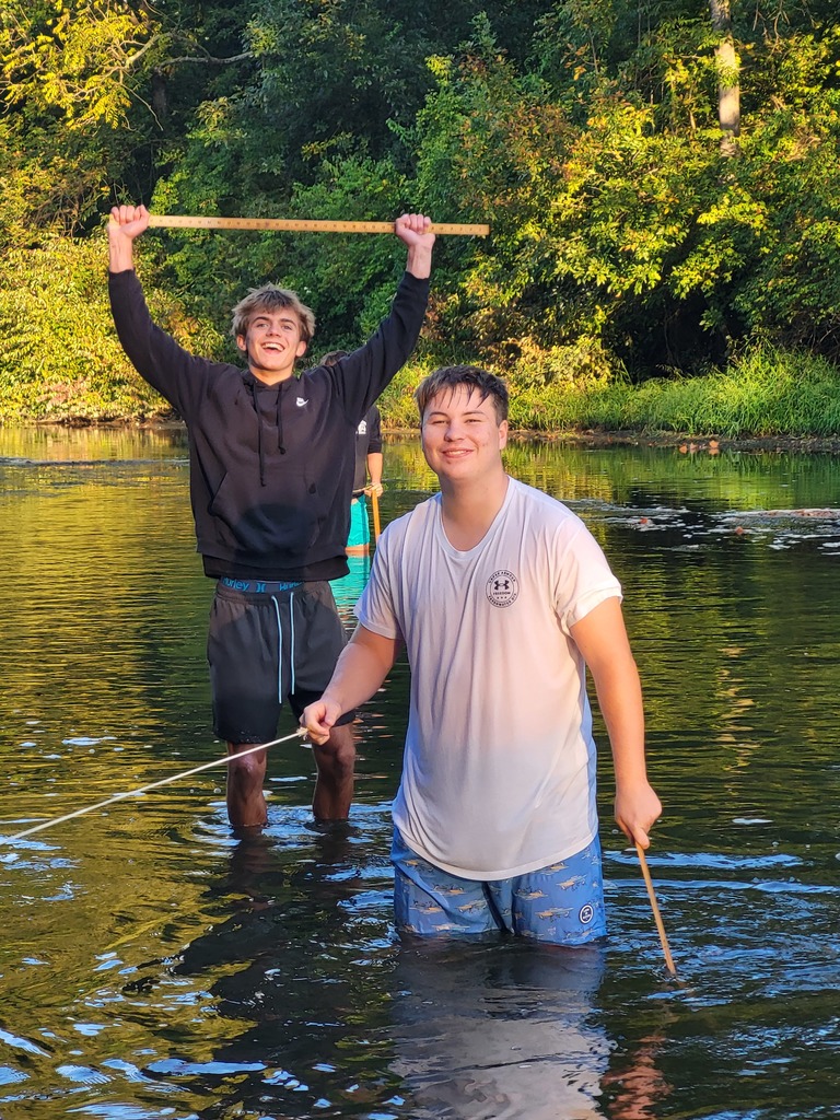 students knee deep in creek 