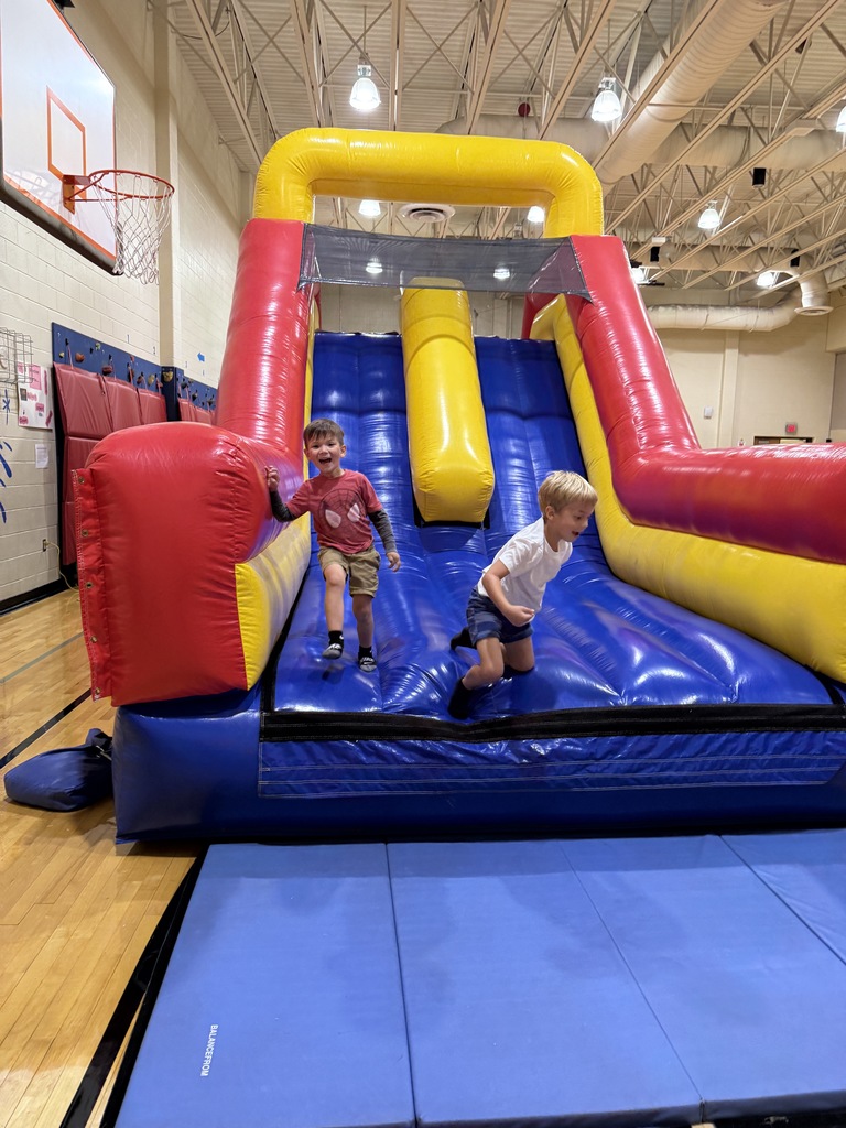 students getting off slide bouncy house