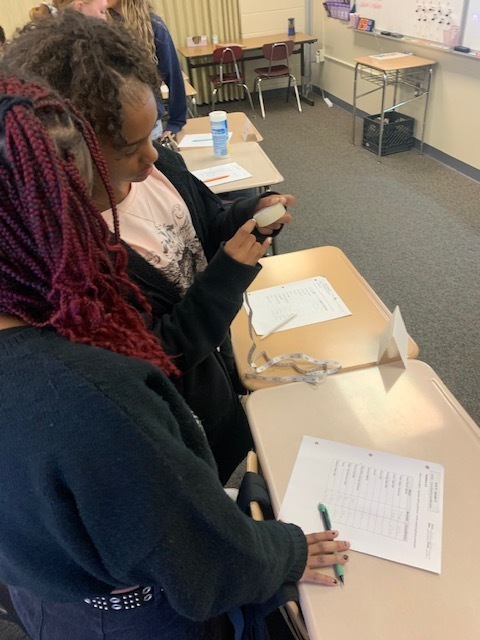 students measuring roll of tape