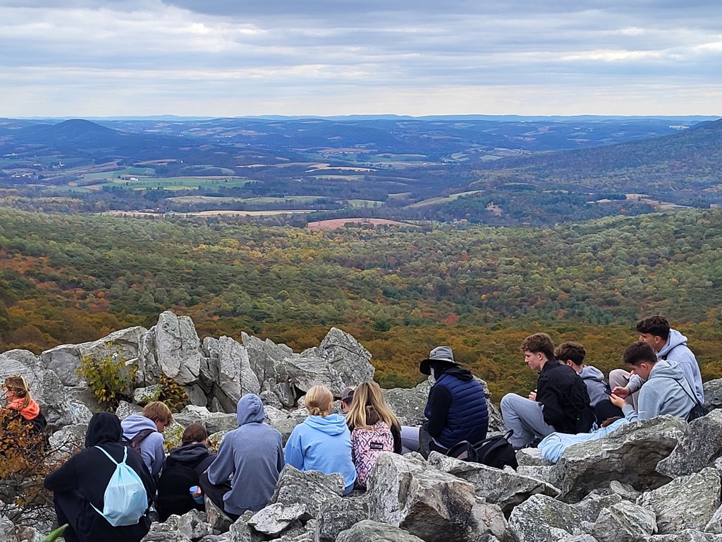 students sitting on rocks looking at view