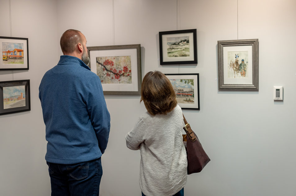 people inspecting the art
