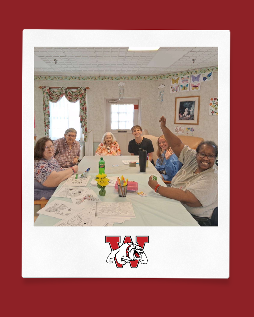 Photo of two high schoolers helping out at a rehab facility; they are playing uno