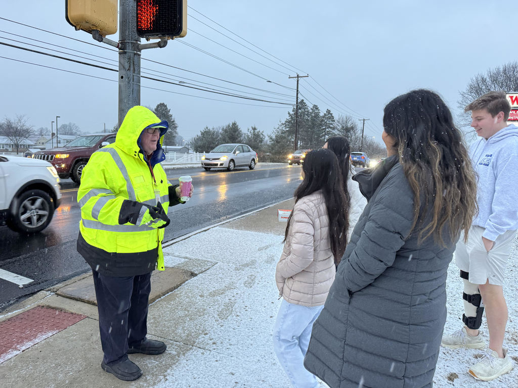 students giving coffee to crossing guard
