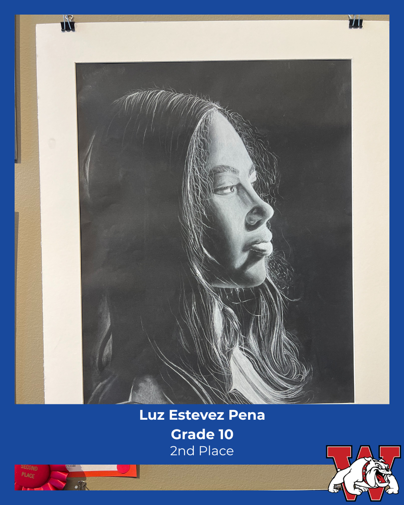 Black-and-white realistic portrait drawing of a young woman in profile, facing right, with detailed shading in her hair and facial features. The artwork is mounted on display with a blue label reading “Luz Estevez Pena, Grade 10, 2nd Place,” along with a Wilson bulldog logo.