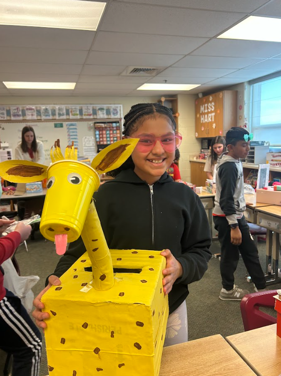 student with valentines giraffe box